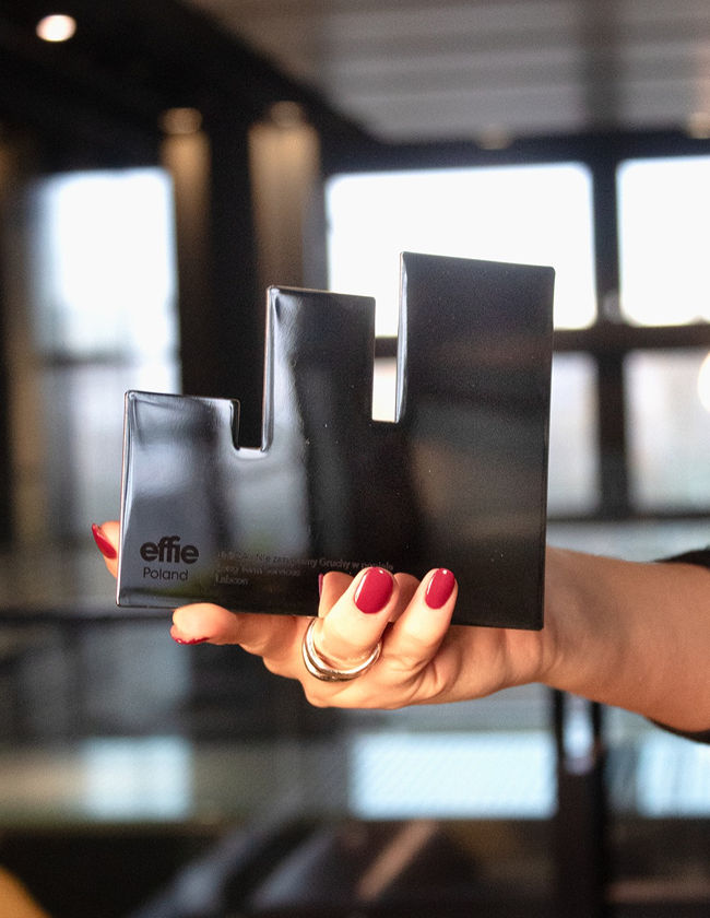 Hand holds prize, office in background